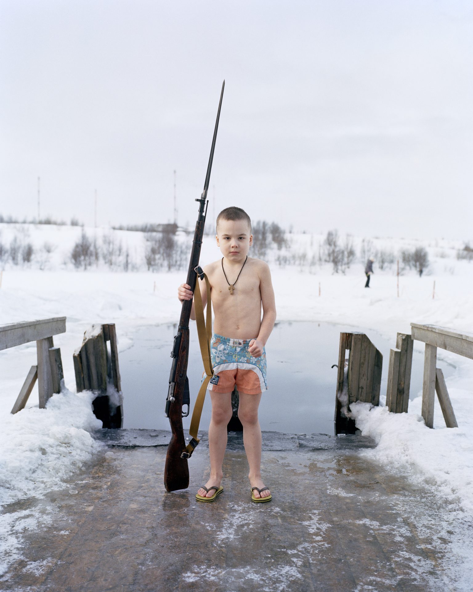 Boy with a rifle at an ice hole, Kola Peninsula