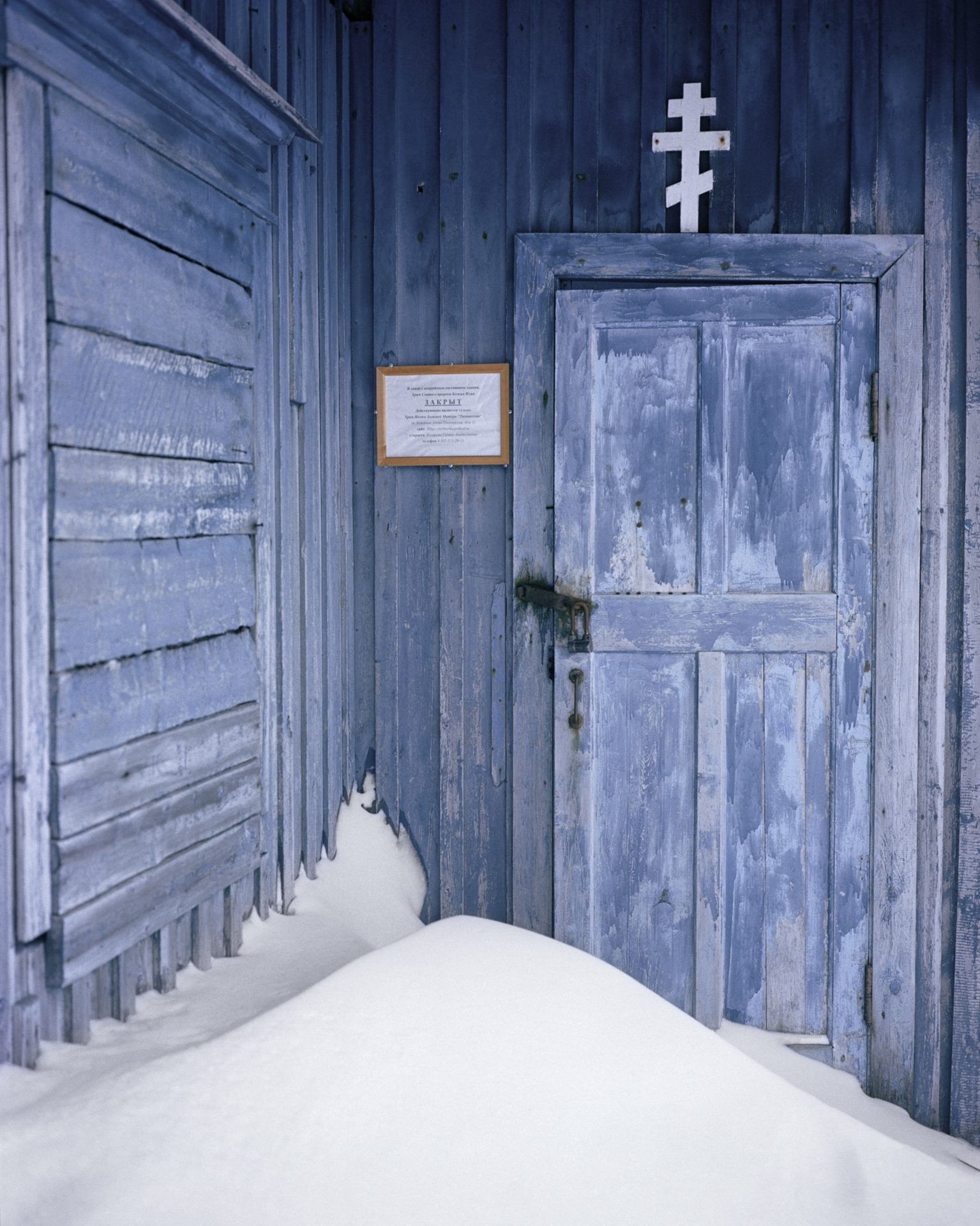 Closed wooden church door in the snow