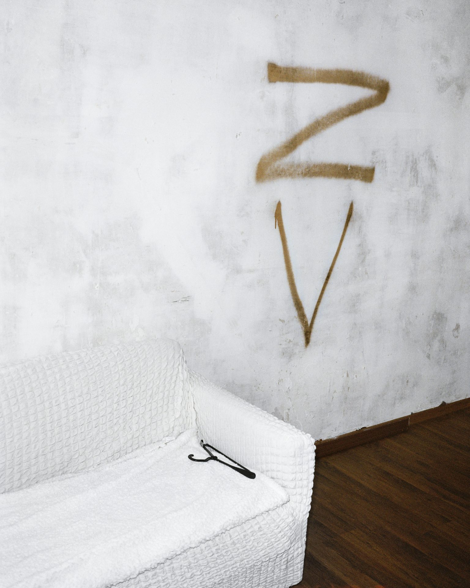 Letters Z and V painted on a wall above a white sofa