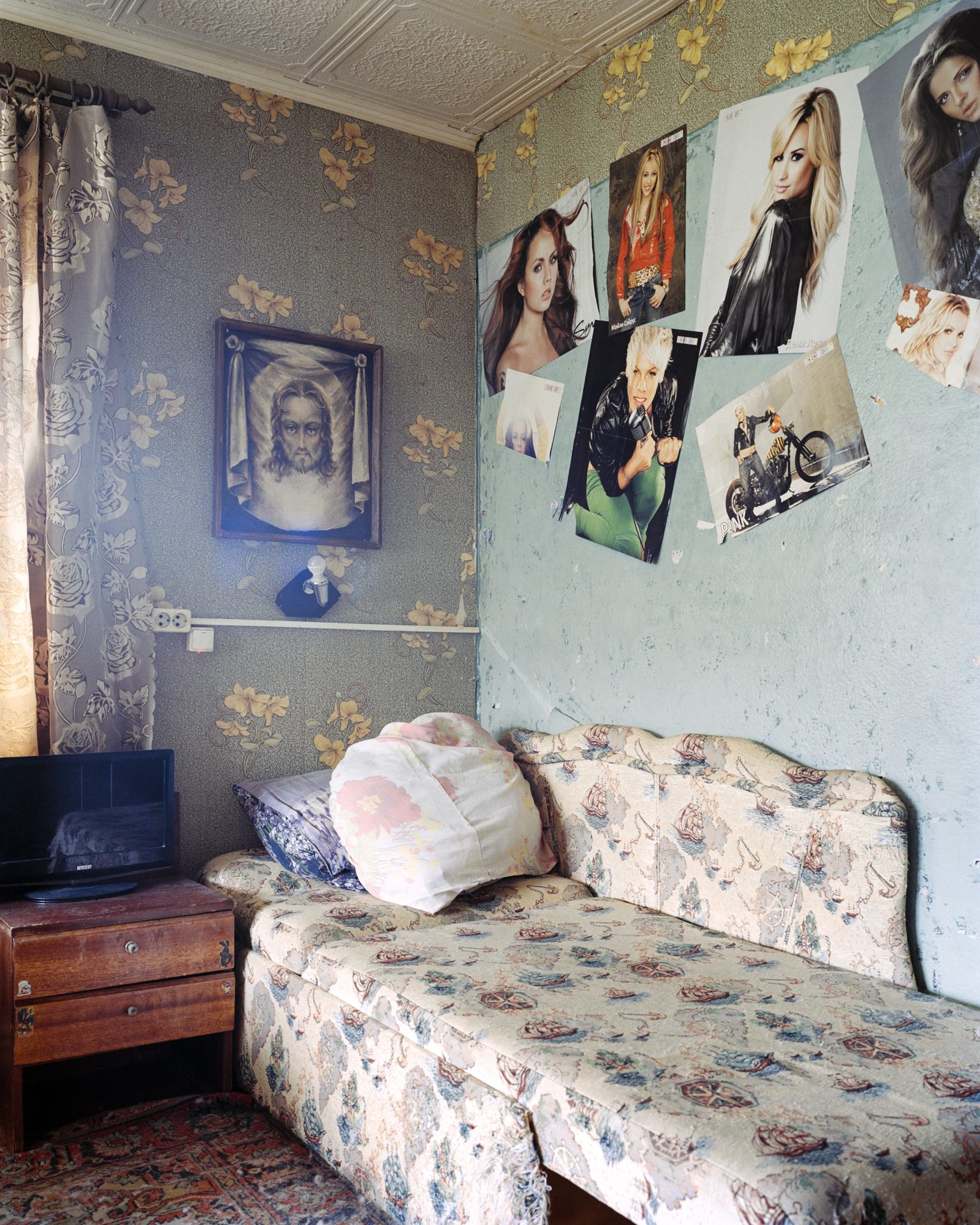 A girl's room, pop posters beside an icon of Christ